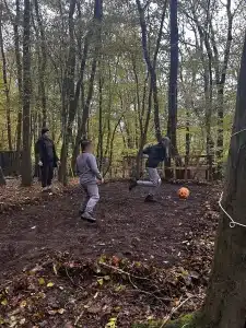 Two boys playing football in the woods
